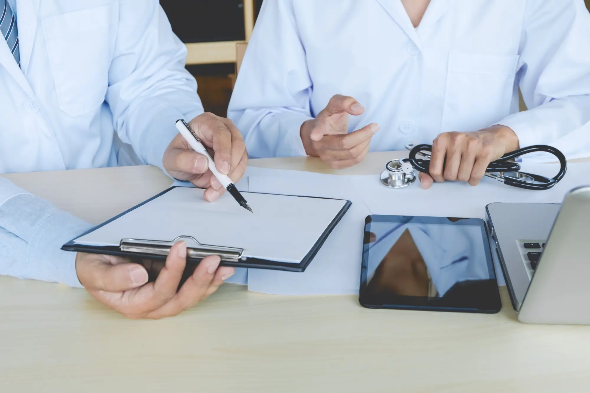 médecins qui font signer un papier sur une plaquette